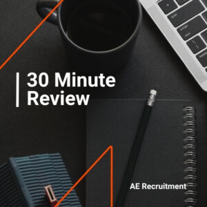 Flat lay with a black coffee, laptop keyboard, notebook, and pencil. White text reads “30 Minute Review” with AE Recruitment branding.