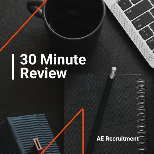 Flat lay with a black coffee, laptop keyboard, notebook, and pencil. White text reads “30 Minute Review” with AE Recruitment branding.